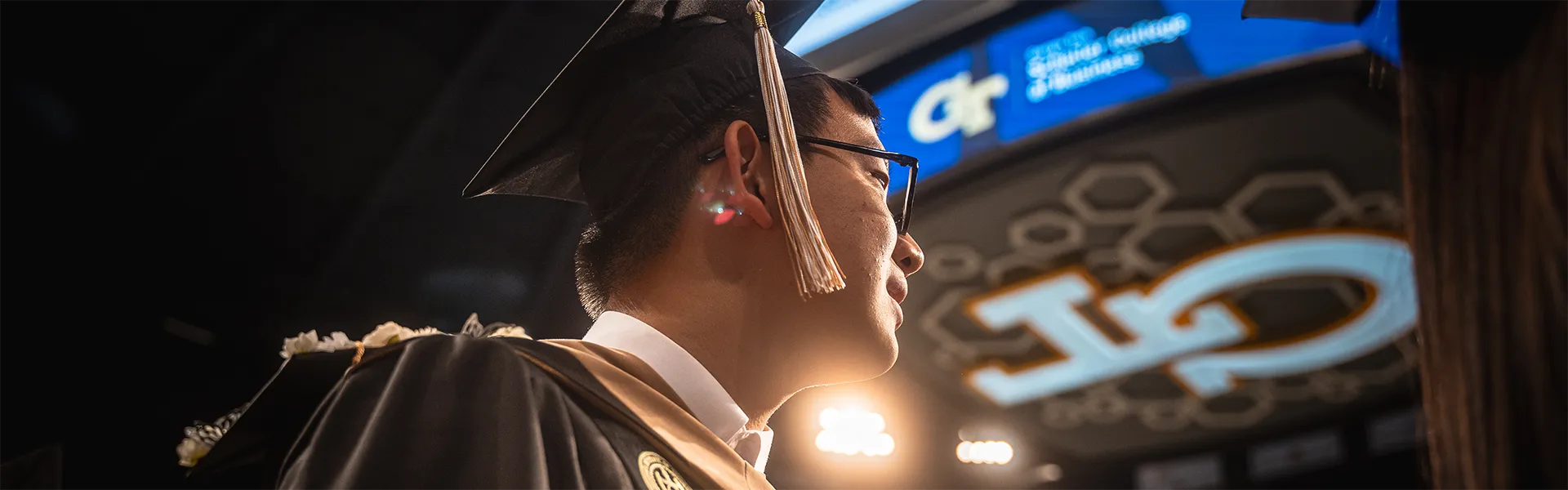 Student graduation walk, looking up at GT logo, proud